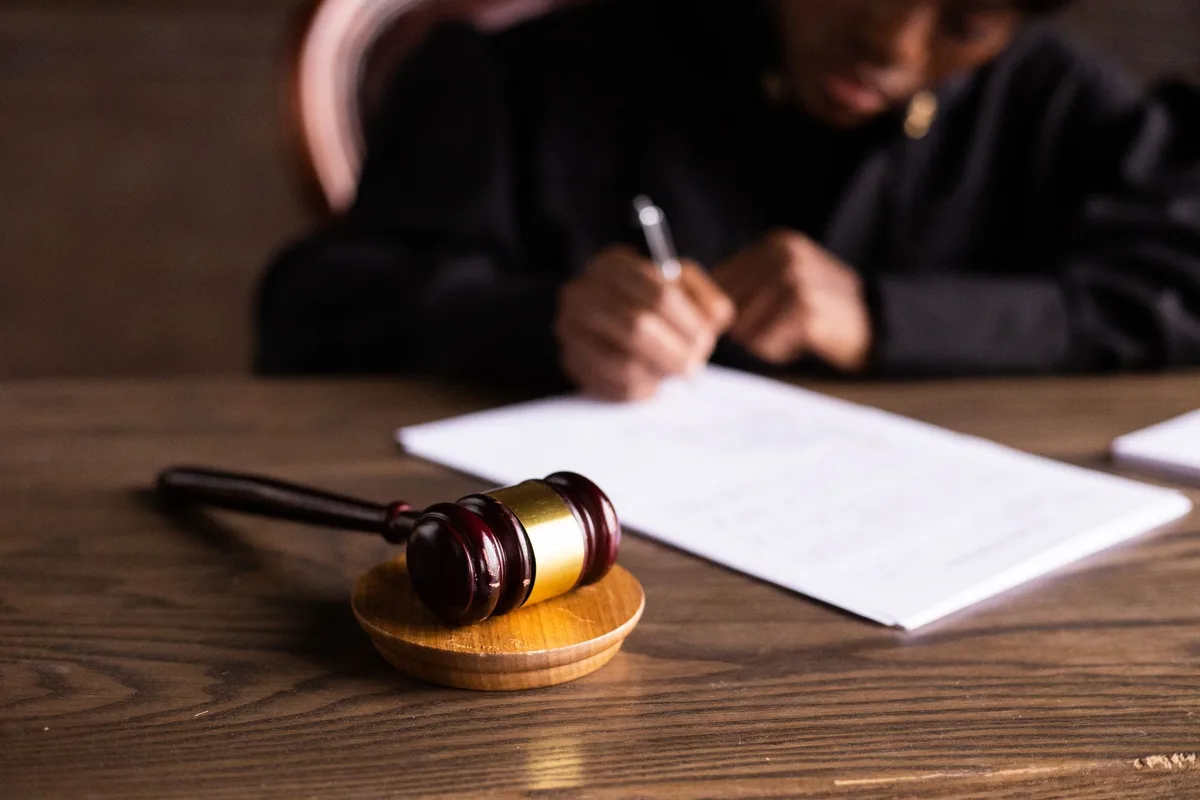 Documentos judiciales y papeles legales sobre un escritorio en una sala de justicia
