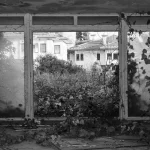 Casa colonial antigua con estructura de madera en deterioro progresivo, mostrando signos de abandono y paso del tiempo