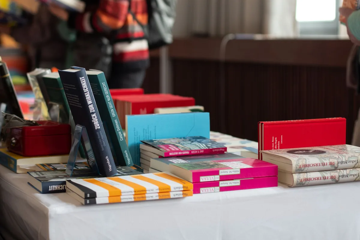 Libros destacados y novedades editoriales exhibidas en mesas durante la feria literaria.