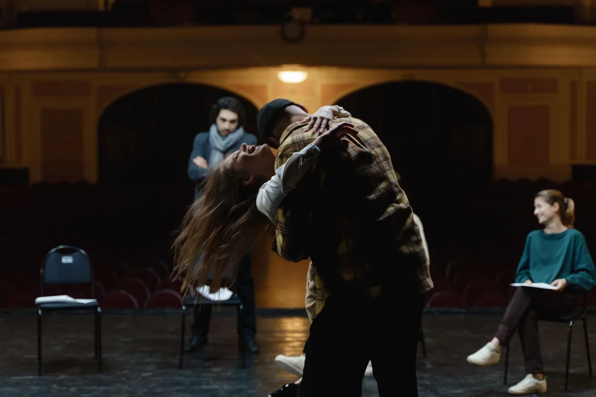 Actores en escena durante una presentación teatral con iluminación dramática