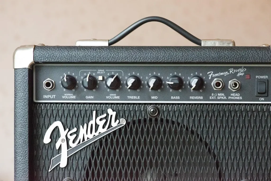 Escenario vacío con micrófono vintage, guitarra apoyada y amplificador, ambiente de camerino