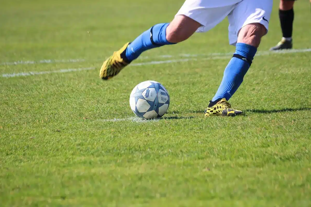 Partido de fútbol en definición por penales con máxima tensión en el estadio.