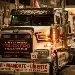 Camiones de carga estacionados sin actividad frente a una planta de acopio agrícola con trabajadores en protesta.