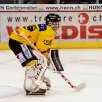 Equipo de hockey sobre césped en formación de celebración con palos levantados en el campo