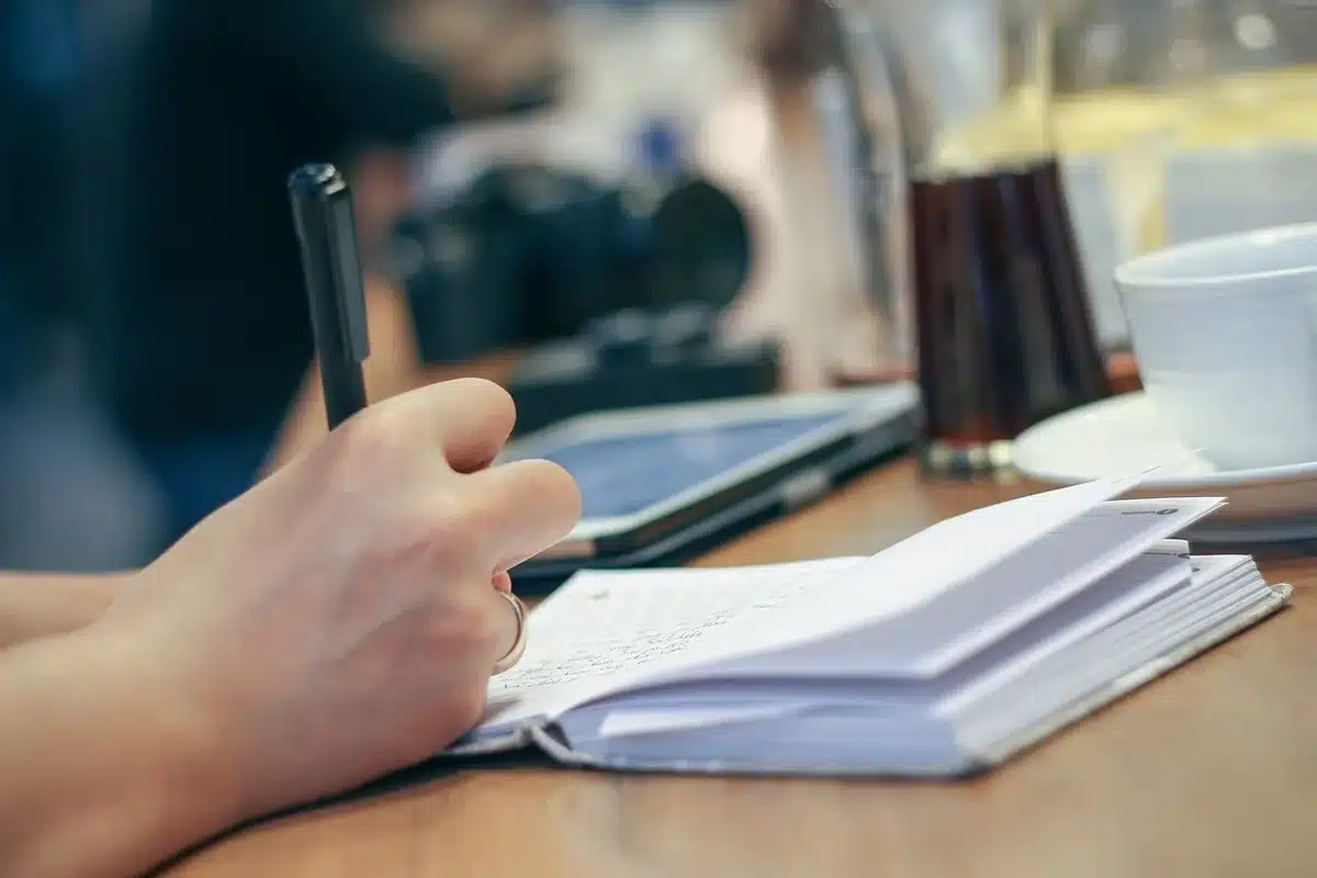 Escritora trabajando en su escritorio con manuscritos y libros