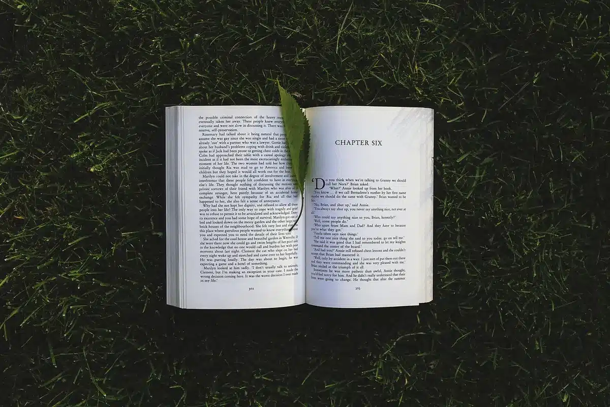 Escenario de ceremonia literaria con libro abierto y trofeo de premio bajo luz cálida