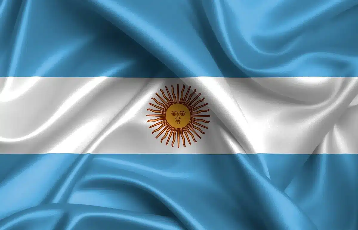 Grupo de manifestantes con banderas y carteles en una plaza argentina