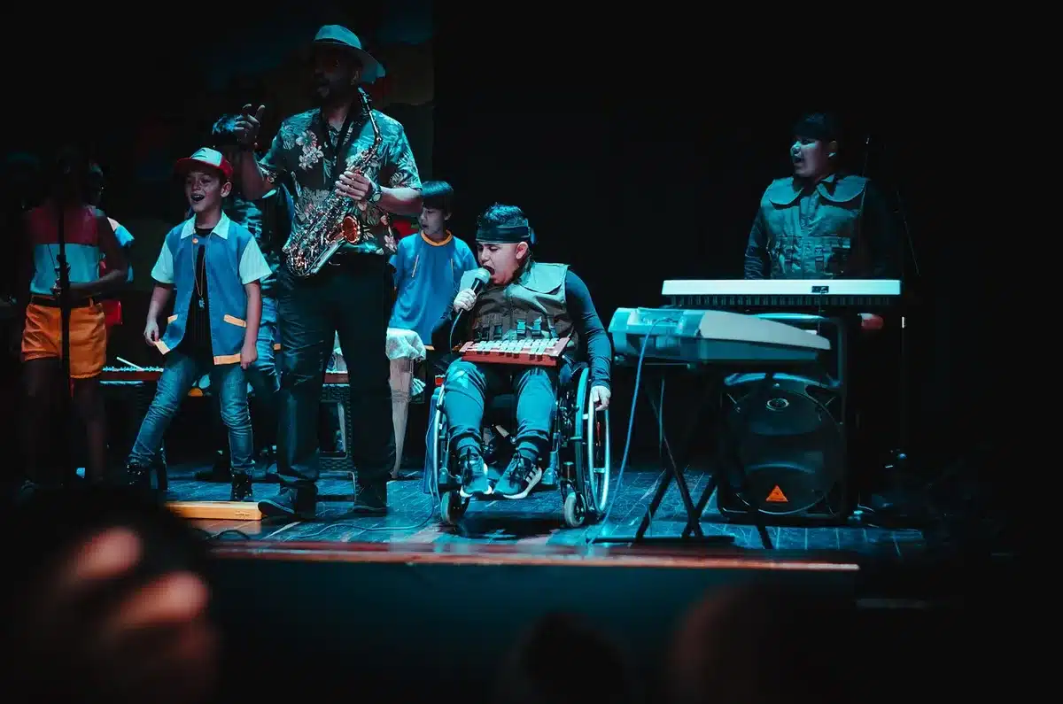 Escena íntima en escenario con actriz y guitarrista interpretando poesía y música