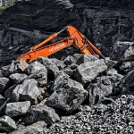 Cantera minera abandonada con maquinaria pesada inactiva y zona de trabajo vacía bajo cielo nublado