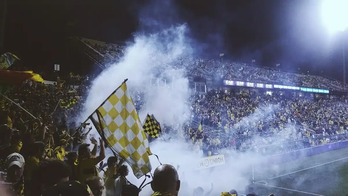 Multitud de aficionados argentinos en el estadio celebrando con banderas y gestos de identidad nacional