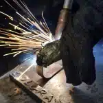 Planta metalúrgica con trabajadores anónimos revisando información en una tablet