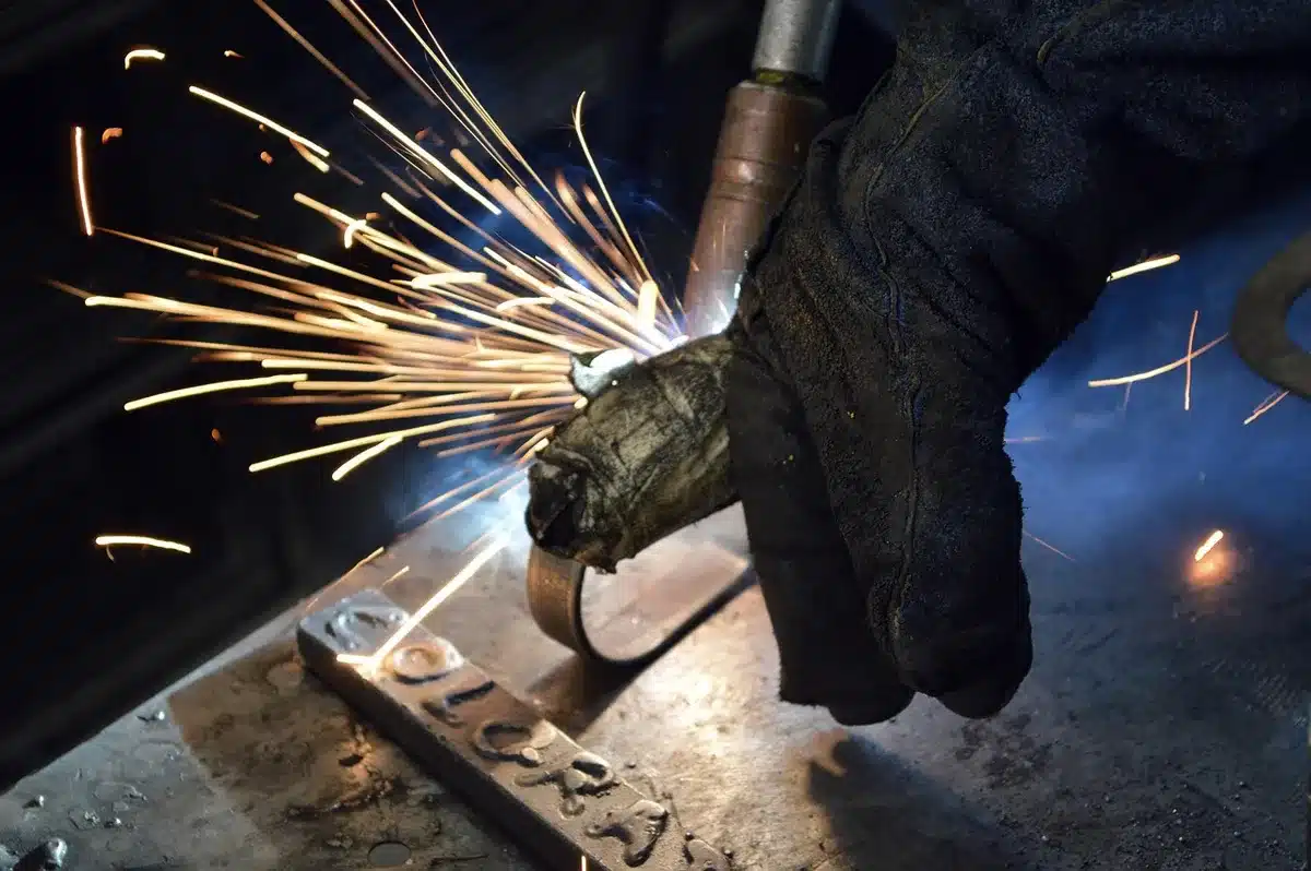 Planta metalúrgica con trabajadores anónimos revisando información en una tablet