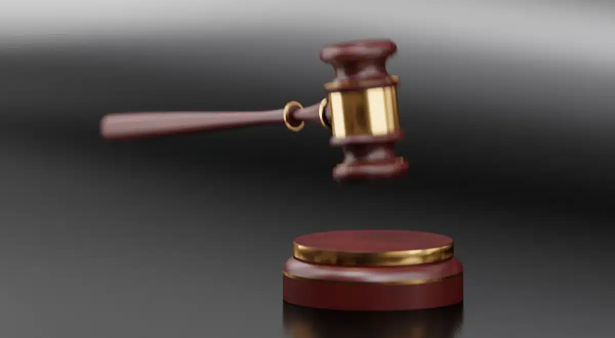Sala de juicio con documentos y martillo judicial sobre la mesa