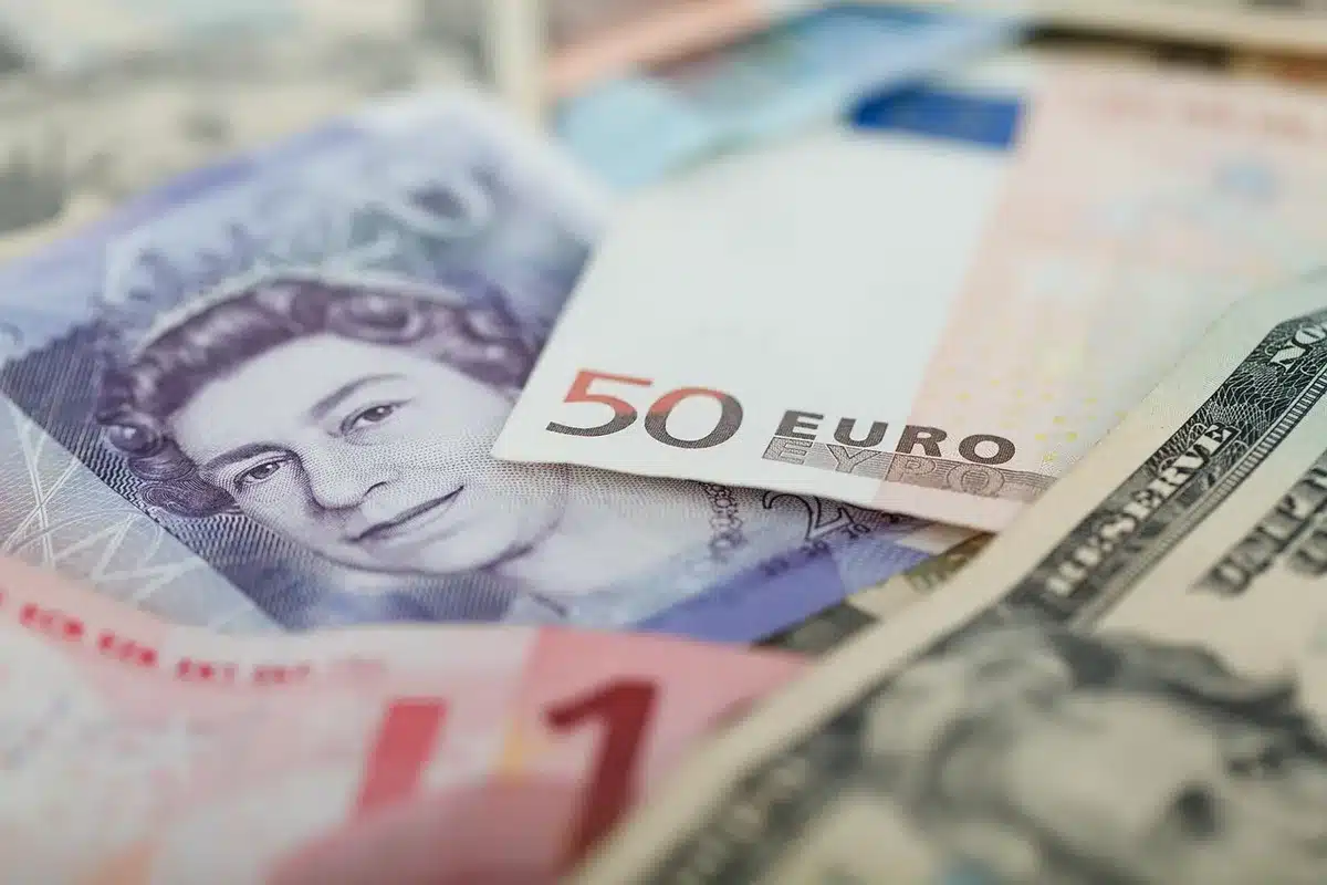 Manos intercambiando un sobre con billetes en un entorno oscuro