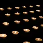 Vigilia con velas y hojas borrosas frente a un edificio judicial en plaza