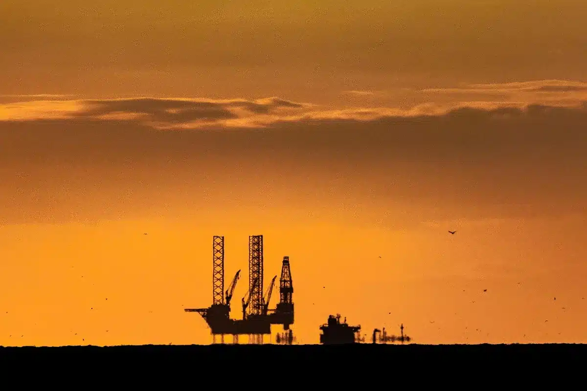 Silhueta de plataforma petrolera y buque de prospección en mar abierto