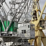 Muelle industrial con contenedores y grúas que evoca comercio exterior y divisas