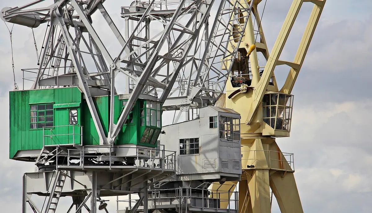 Muelle industrial con contenedores y grúas que evoca comercio exterior y divisas
