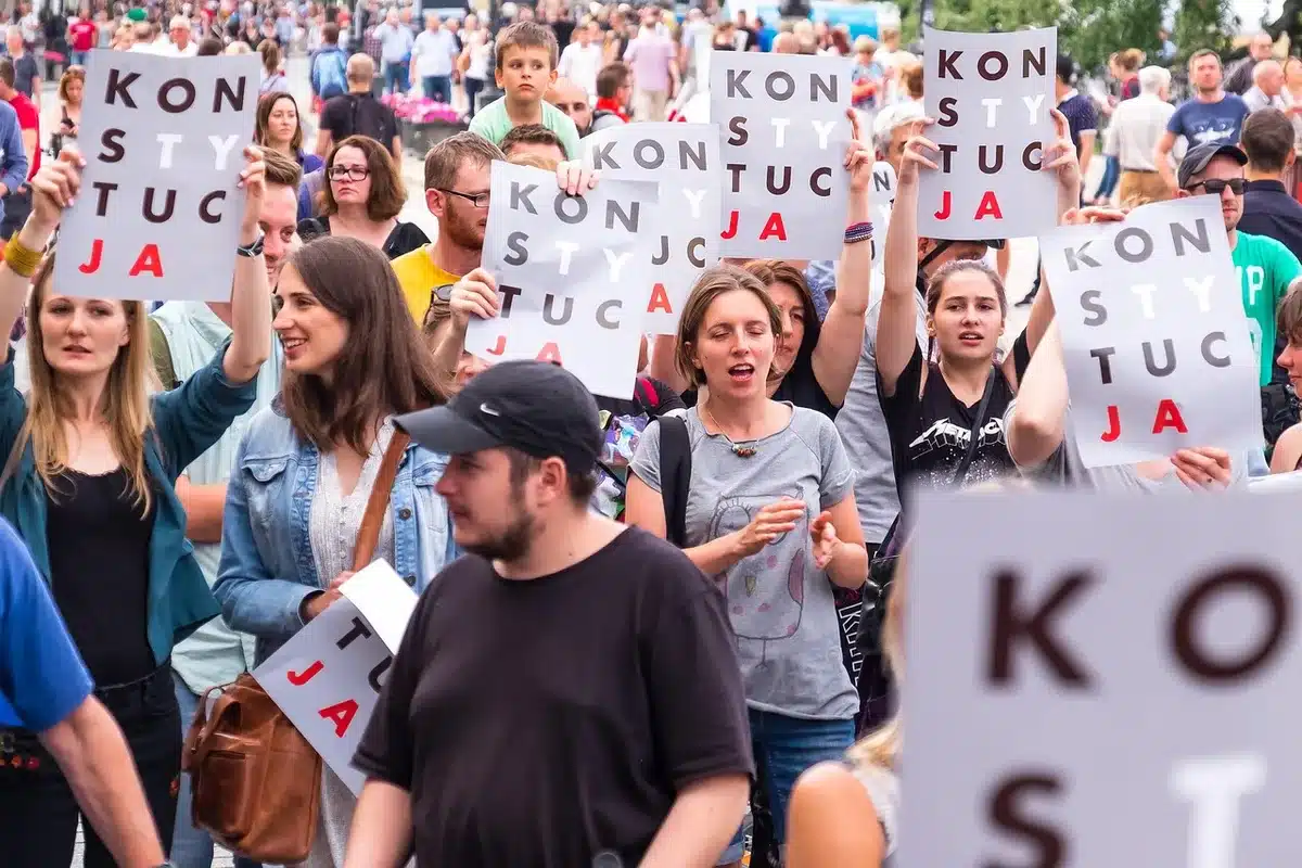Pancartas y banderas en una movilización rumbo a un edificio público